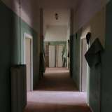 Accediamo quindi nel secondo, dove una porta aperta ci invita a entrare.  Saliamo le scale e ci ritroviamo di fronte a un lungo corridoio le cui mura colore verde acceso trasudano frammenti di vita che si ostinano a voler rimanere imprigionati in quel luogo